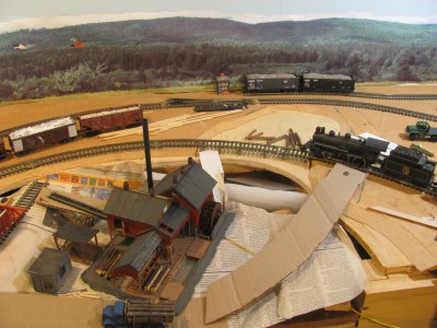 This is Sheffield Mills under construction. The tracks cross the mill pond on a trestle. The mill is an approximation as the CVR tracks were farther away from the mill and I am not sure it was still operating  when the DAR went through, but it is a fun model with a working waterwheel and saw blade. It is a kitbash of a German mill modified to look Nova Scotian, inspired by the Bangor Mill in Digby County: http://www.dardpi.ca/wiki/index.php?title=Bangor_Sawmill
